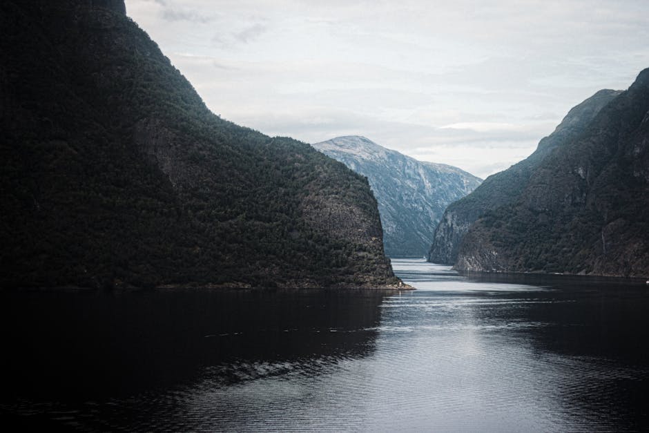 Serene view of a Norwegian fjord surrounded by towering mountains.